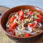 Spaghetti con pesto di acciughe, noci e limone su crema di burrata