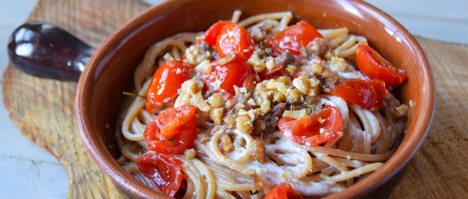 Spaghetti con pesto di acciughe, noci e limone su crema di burrata