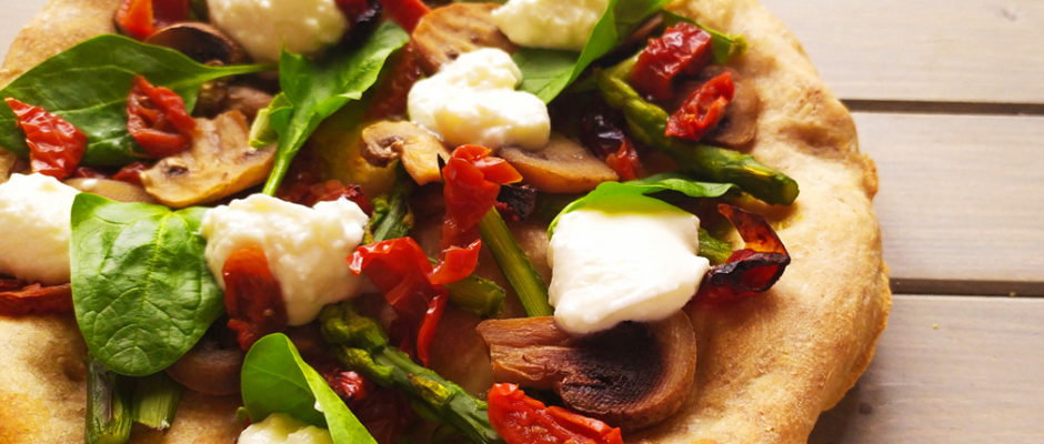 Pizza con pomodori secchi, spinaci, asparagi e spuma di burrata